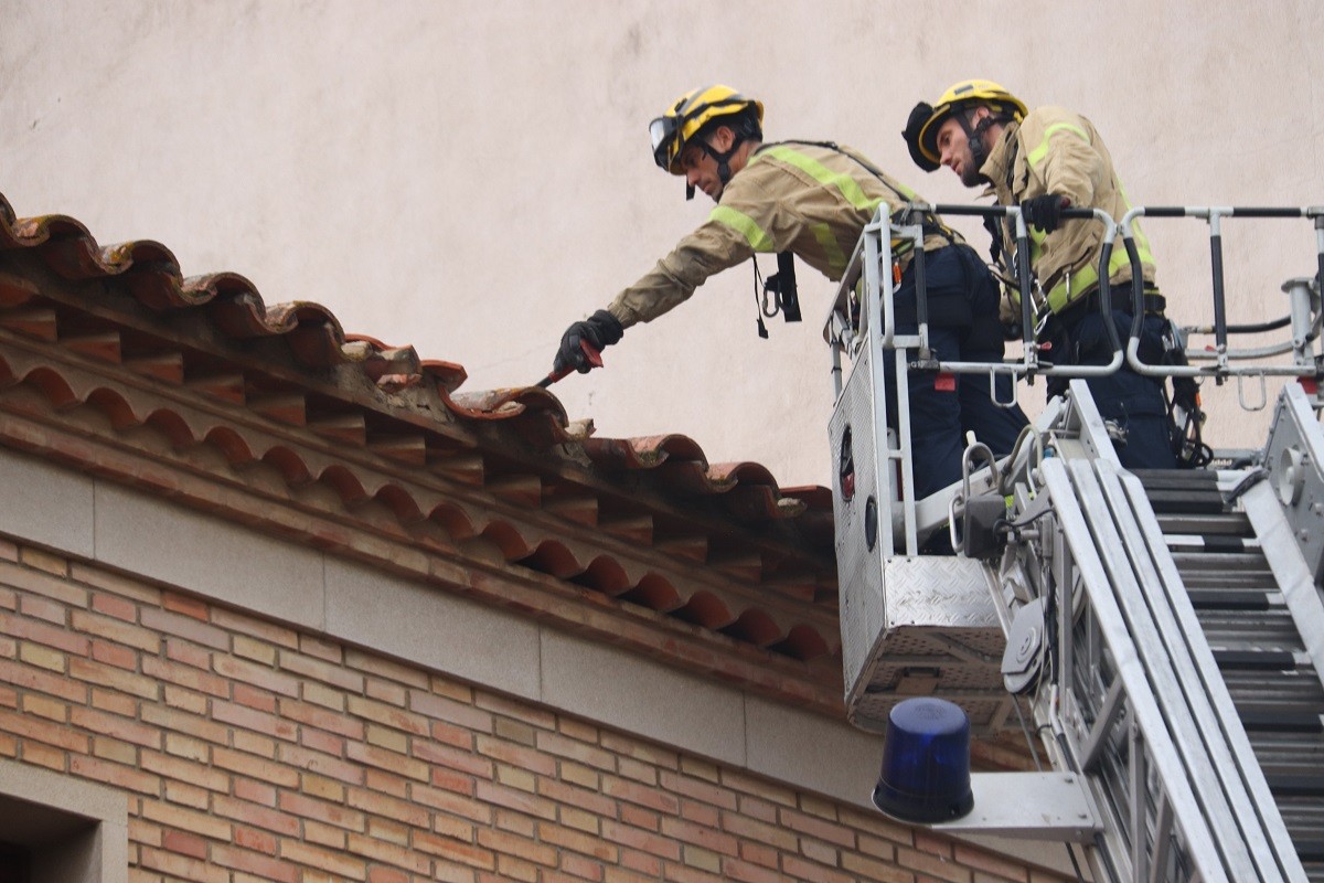Els Bombers inspeccionant una teulada malmesa pel temporal - ACN Els Bombers inspeccionant una teulada malmesa pel temporal - ACN