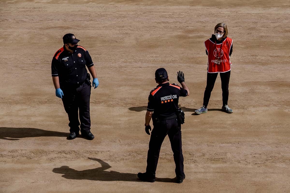 Dos voluntaris de protecció civil concersant amb una agent de mercats. - Adrià Costa Dos voluntaris de protecció civil concersant amb una agent de mercats. - Adrià Costa