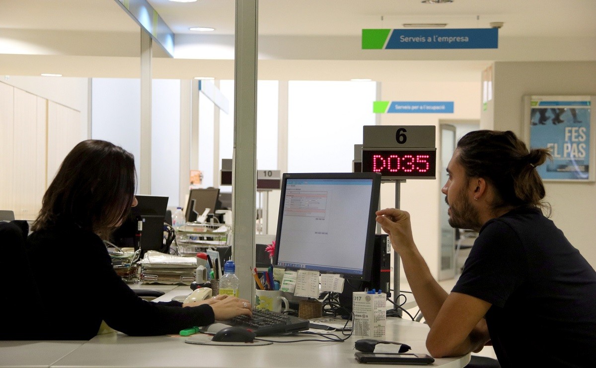 Una treballadora del SOC i un home conversen en un dels punts d'atenció del Servei d'Ocupació de Catalunya - ACN Una treballadora del SOC i un home conversen en un dels punts d'atenció del Servei d'Ocupació de Catalunya - ACN