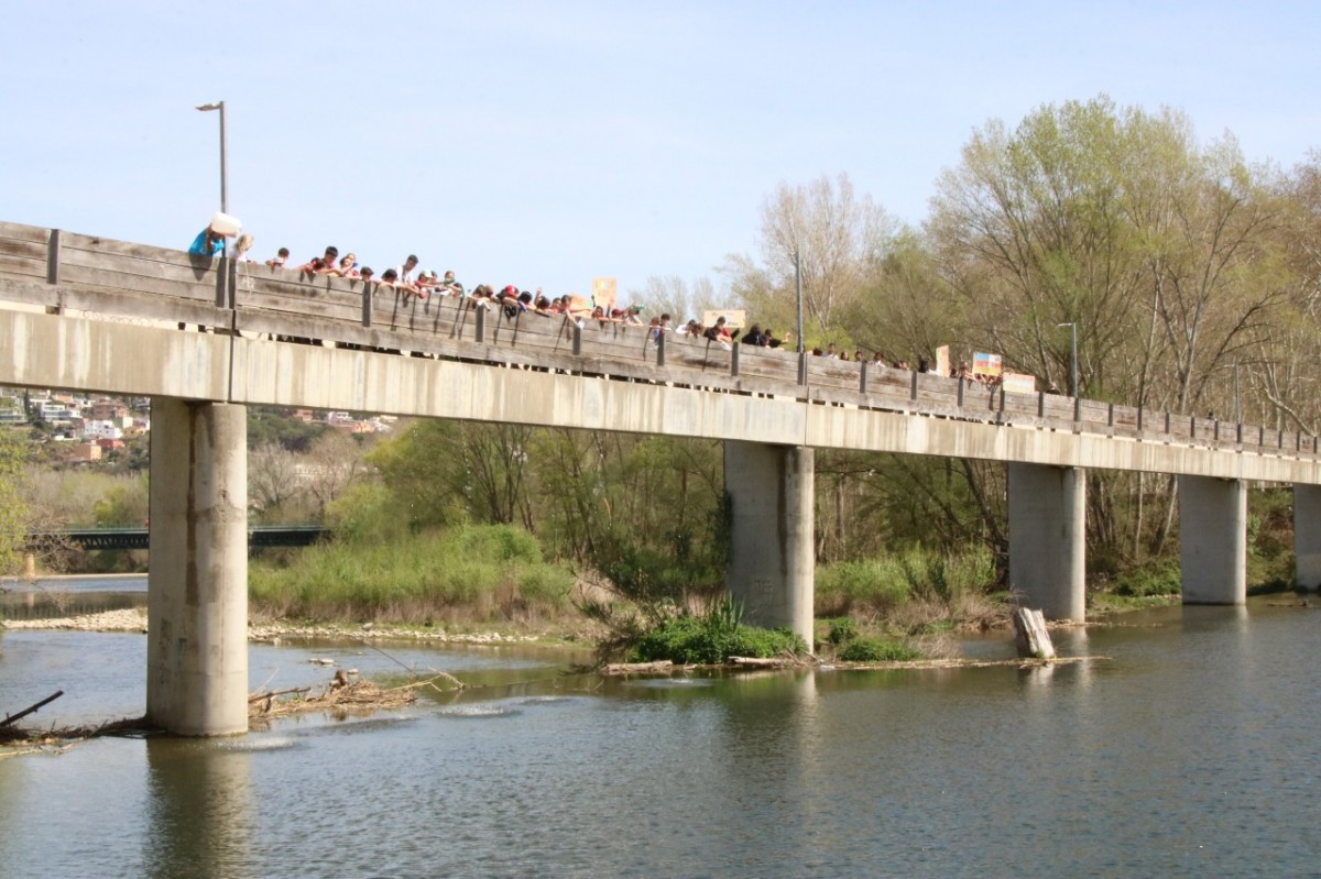 Els alumnes de les escoles verdes de Girona, durant l'abocament de palanganes per reclamar més cabal al Ter - ACN