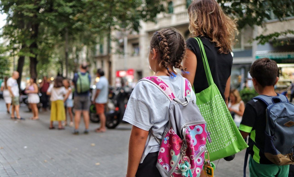 Infants amb la seva mare preparant l'inici del nou curs escolar - Hugo Fernández
