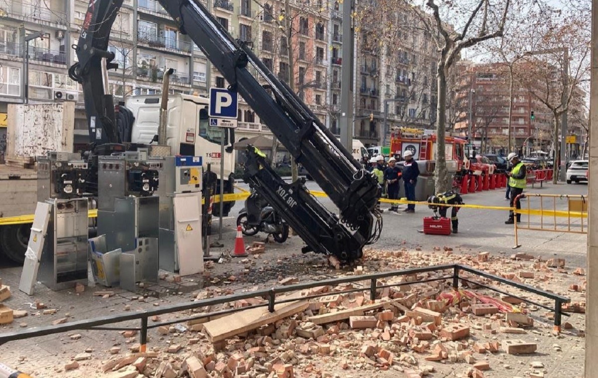 El braç d'una grua destrossa completament un balcó a Barcelona