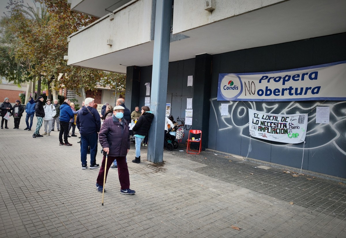 Francisco Liñán, amb el bastó, passejant davant el local on es vol obrir un supermercat i els veïns volen usos públics - D.C.