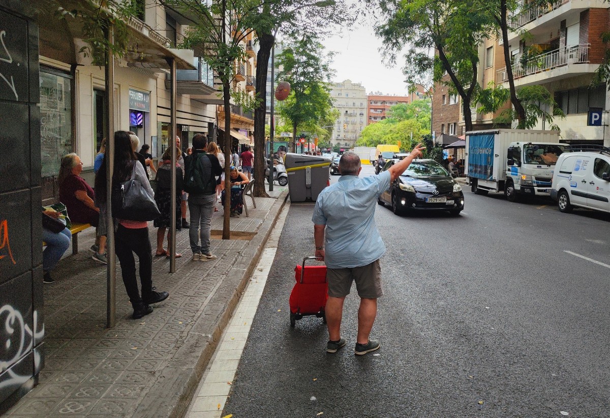 Un home amb un carret de la compra demana un taxi, per la vaga d'autobusos - David Cobo
