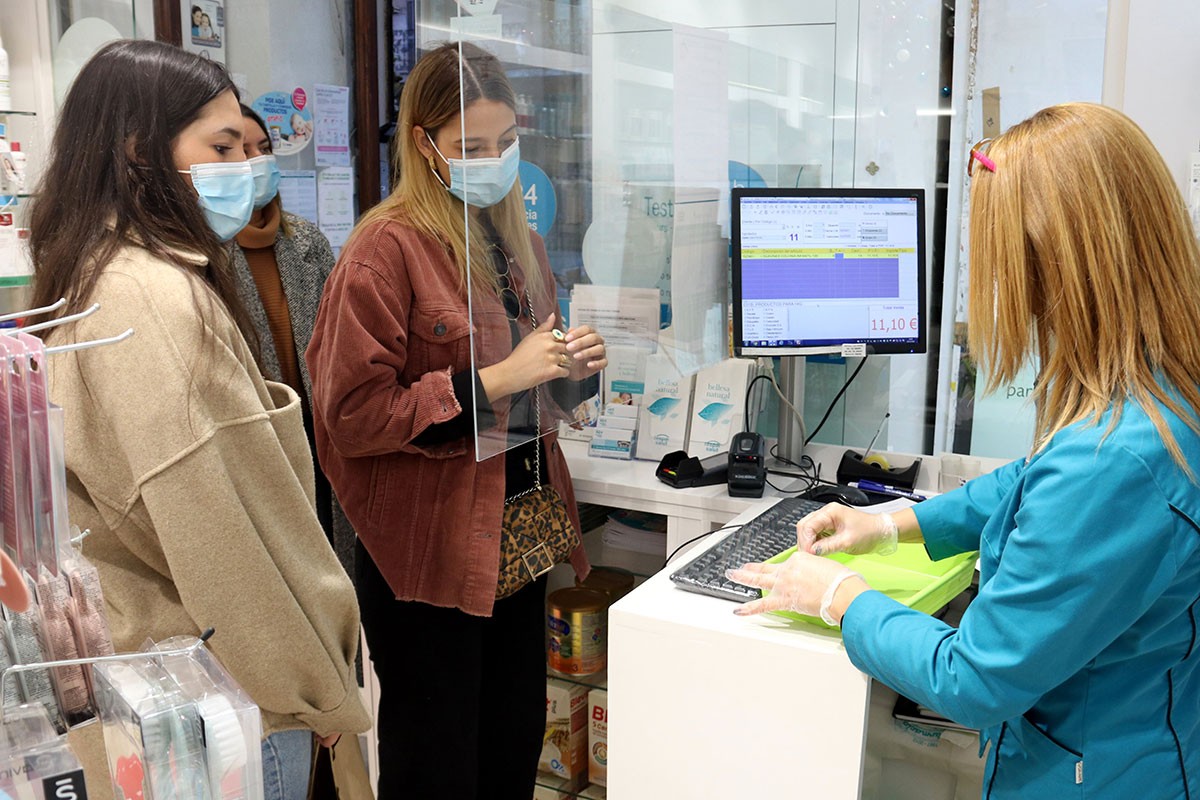 Unes noies, fent cua per fer-se un test a una farmàcia. - ACN