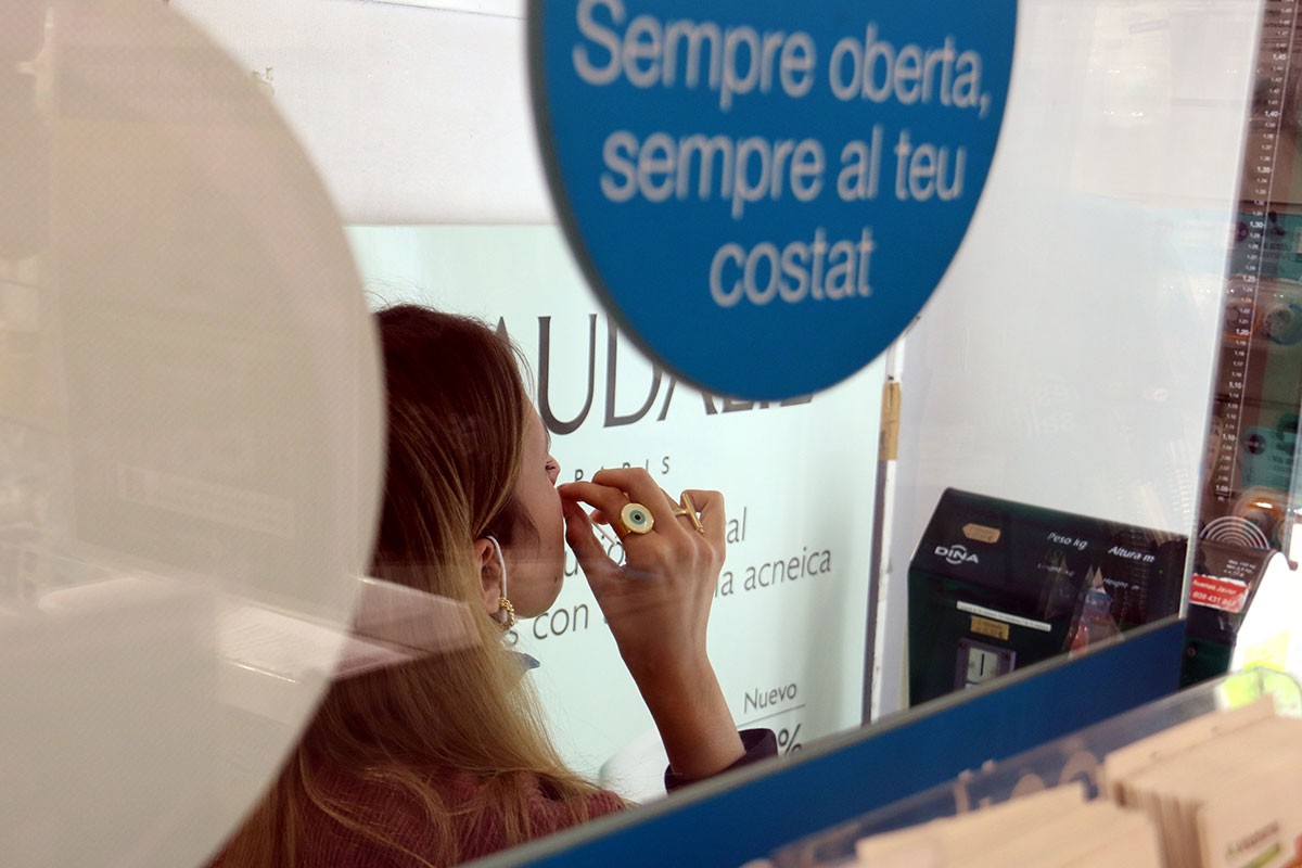 Una noia, fent-se un test d'antigen en una farmàcia. - ACN