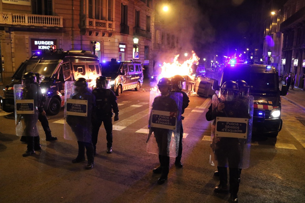 Fila dels Mossos davant d'un contenido en flames - Àlex Recolons / ACN
