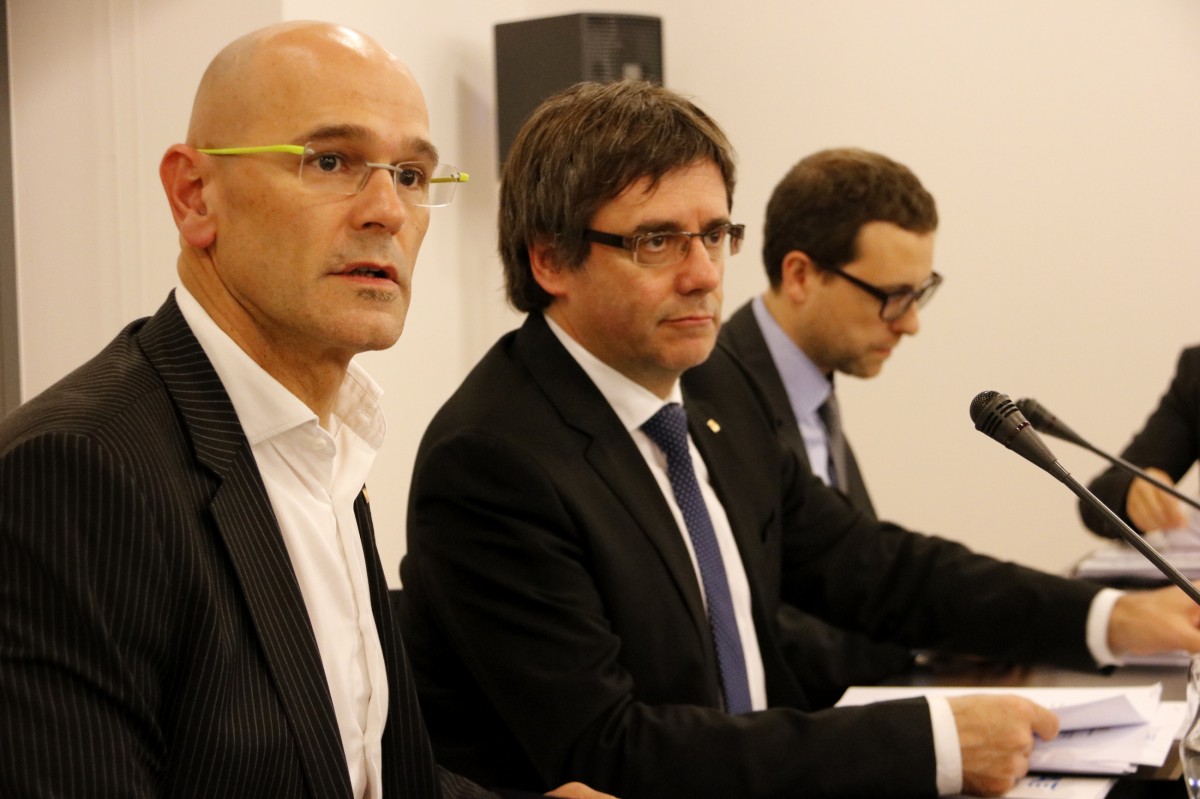 Carles Puigdemont, acompanyat de Raül Romeva i Albert Royo, dos dels investigats en la causa contra l'acció exterior de la Generalitat - ACN