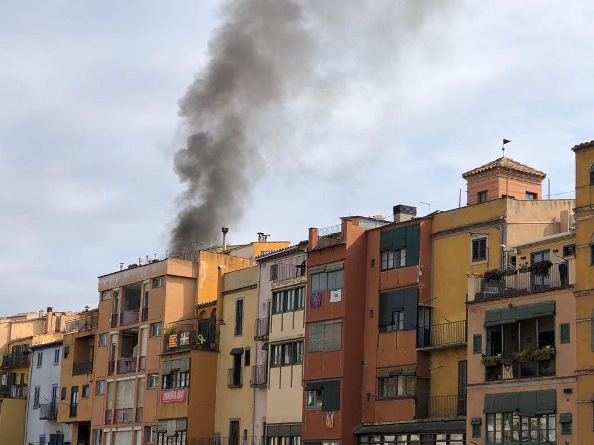 La zona del riu a Girona, amb una columna de fum negre visible provinent del Barri Vell - ACN