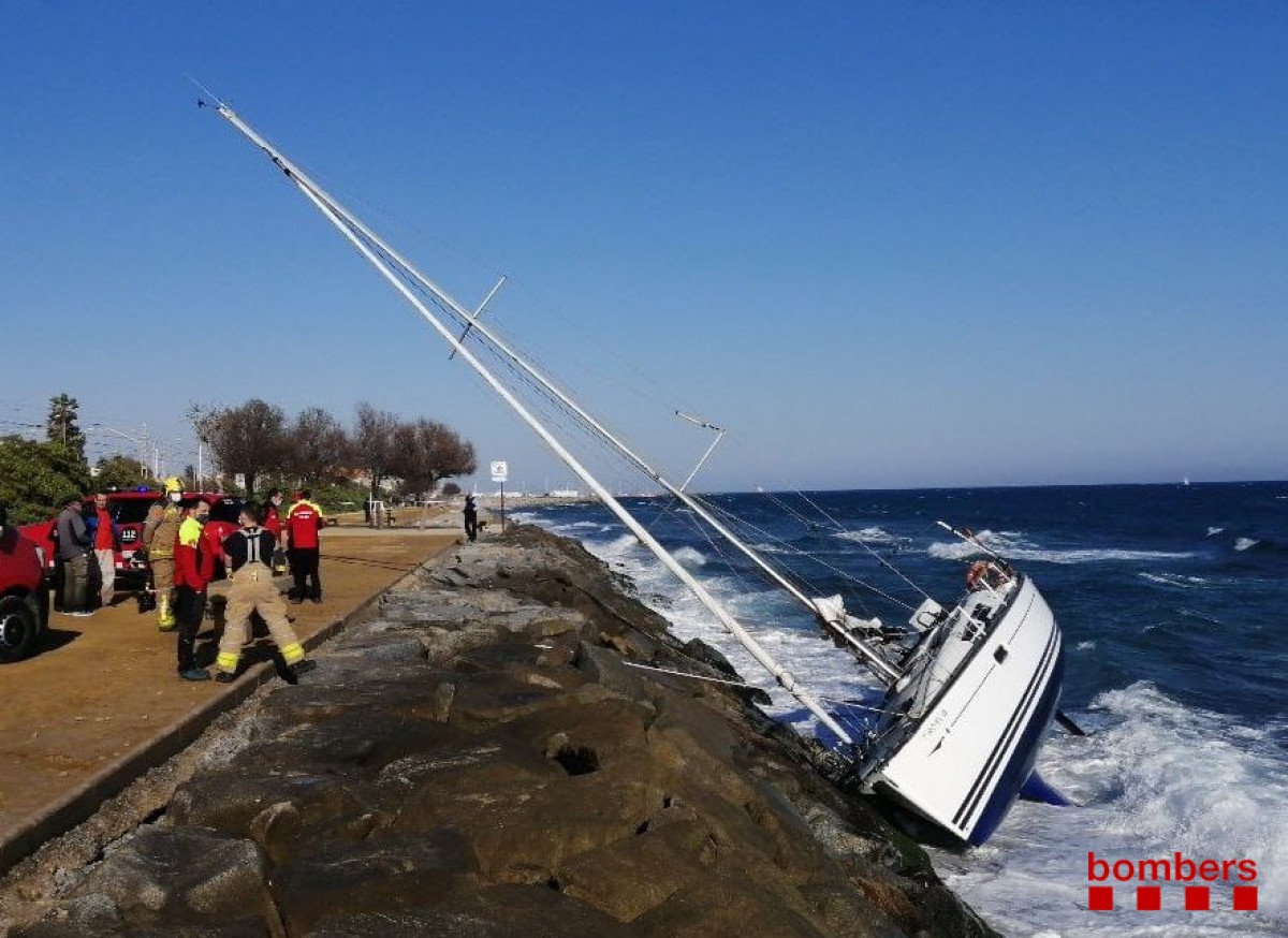 Els Bombers rescaten tres persones d'un veler atrapat en unes roques a Premià de Mar