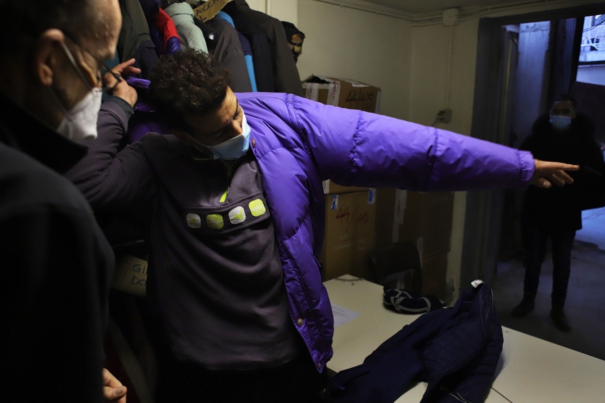 Un jove es prova un anorac per anar protegit del fred quan intenti creuar de nit a França. - Sergi Cámara