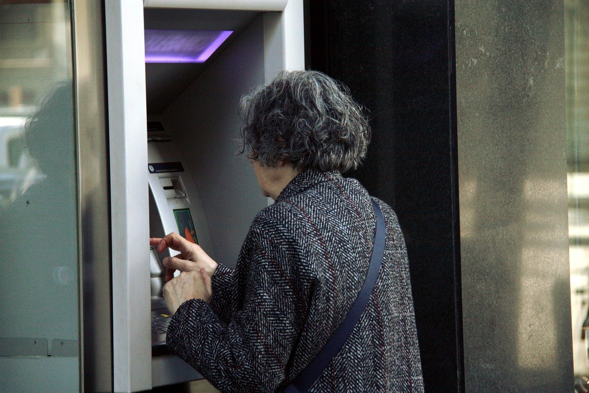 Una persona utilitzant un caixer automàtic. - ACN