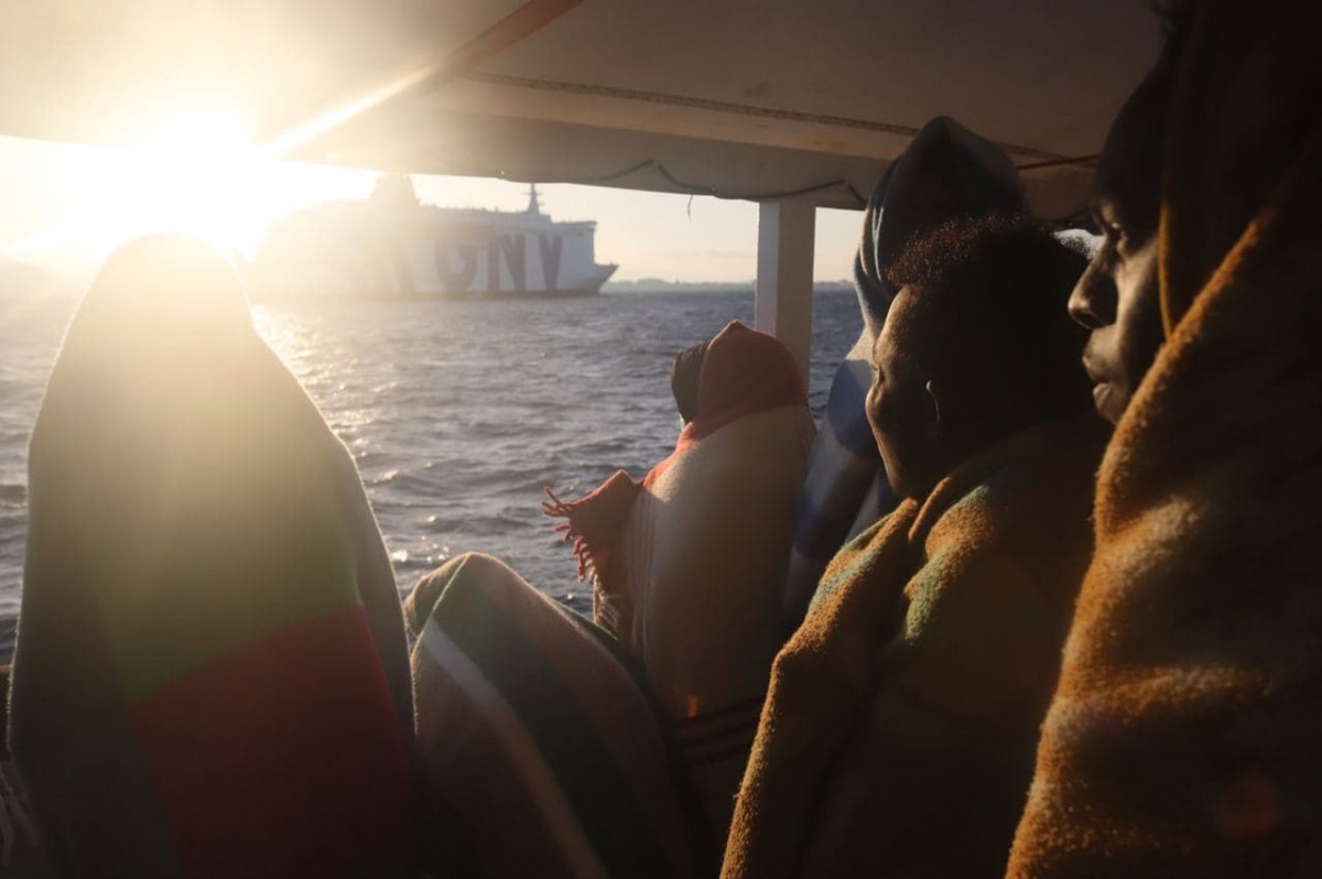 Algunes de les persones miren la nau on passaran la quarantena des de la distància - Sergi Cámara