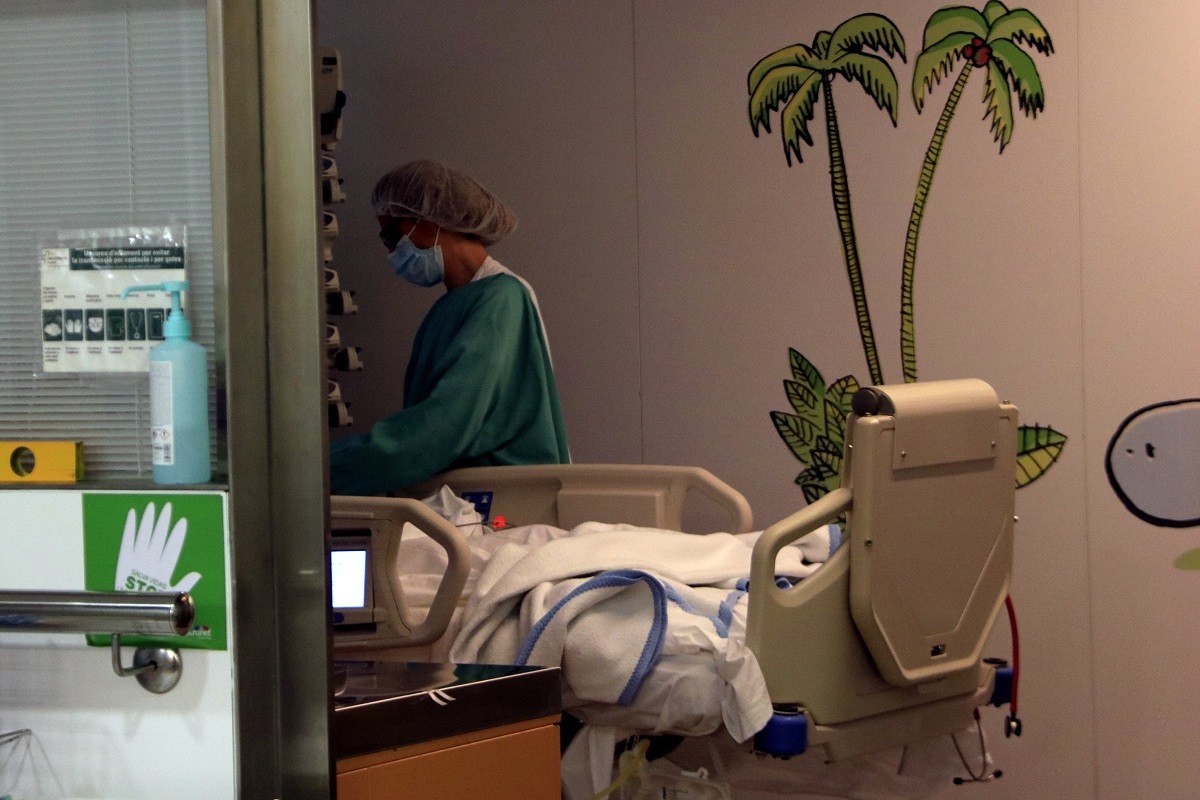 Una professional atén un pacient a l'UCI pediàtrica de l'Hospital Vall d'Hebron. - ACN