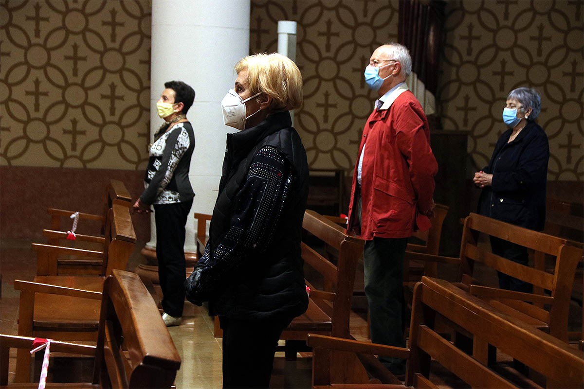 Feligresos a missa, a la parròquia de Sant Pau de Tarragona, amb mascaretes i mantenint distàncies en els bancs. - Roger Segura/ACN