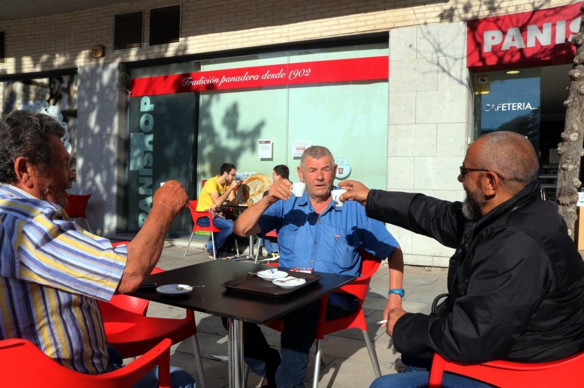 Tres clients de la cafeteria Panishop de Tarragona brindant amb les tasses de cafè - ACN