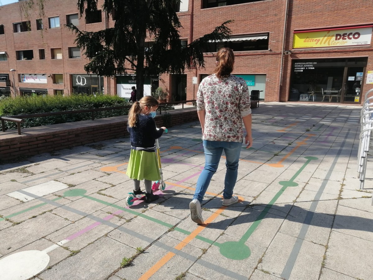 Una mare i la seva filla jugant a una plaça del centre de Sant Cugat  - Sergi Baixas