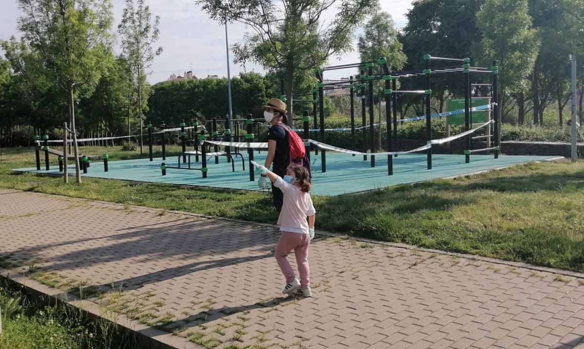 Una nena assenyalant com ha cresut la gespa durant aquests dies de confinament a Sant Cugat del Vallès - Sergi Baixas