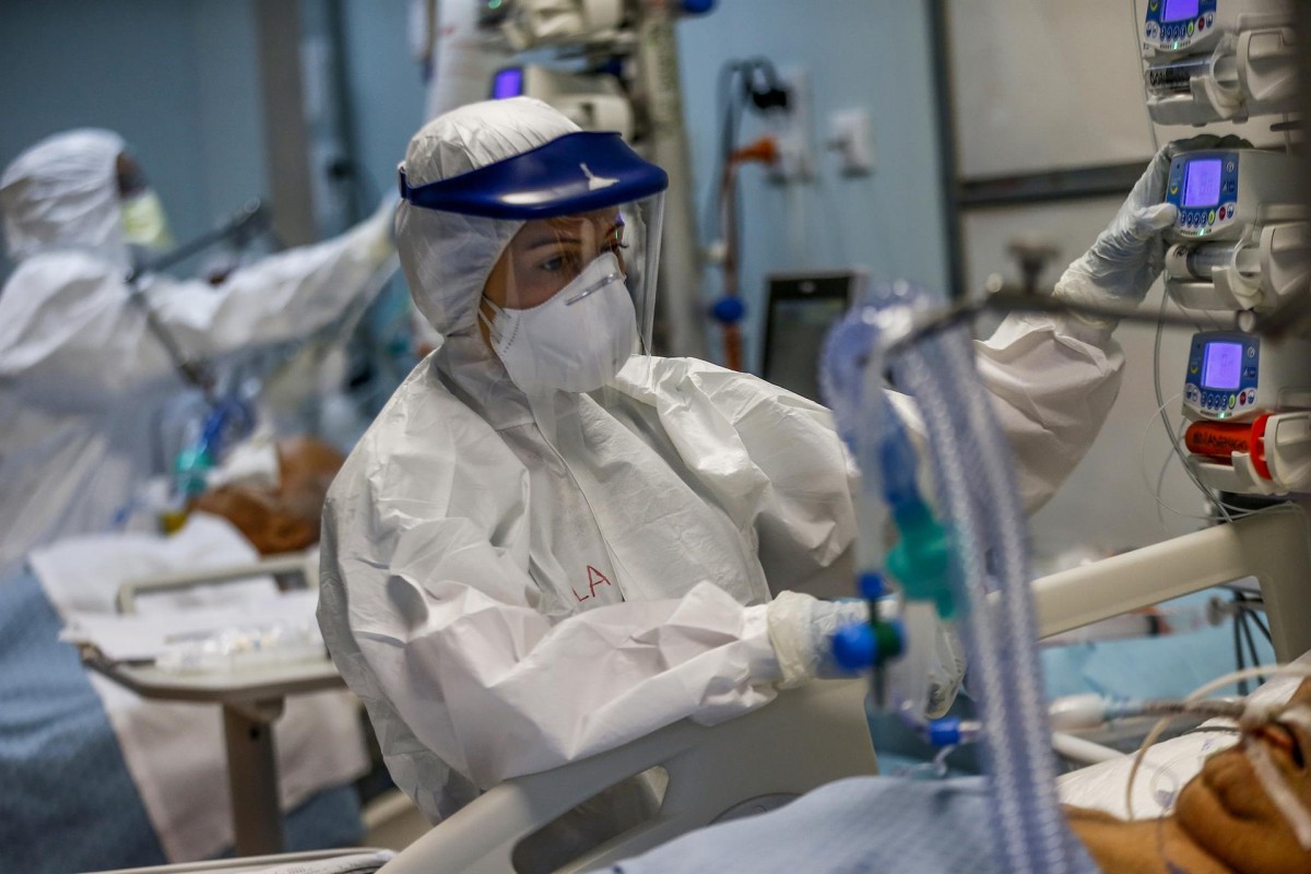 Un sanitari atenent un pacient a l'UCI - Europa Press