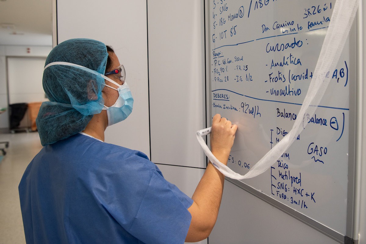 Una professional sanitària del Clínic pren notes en una pissarra - ACN