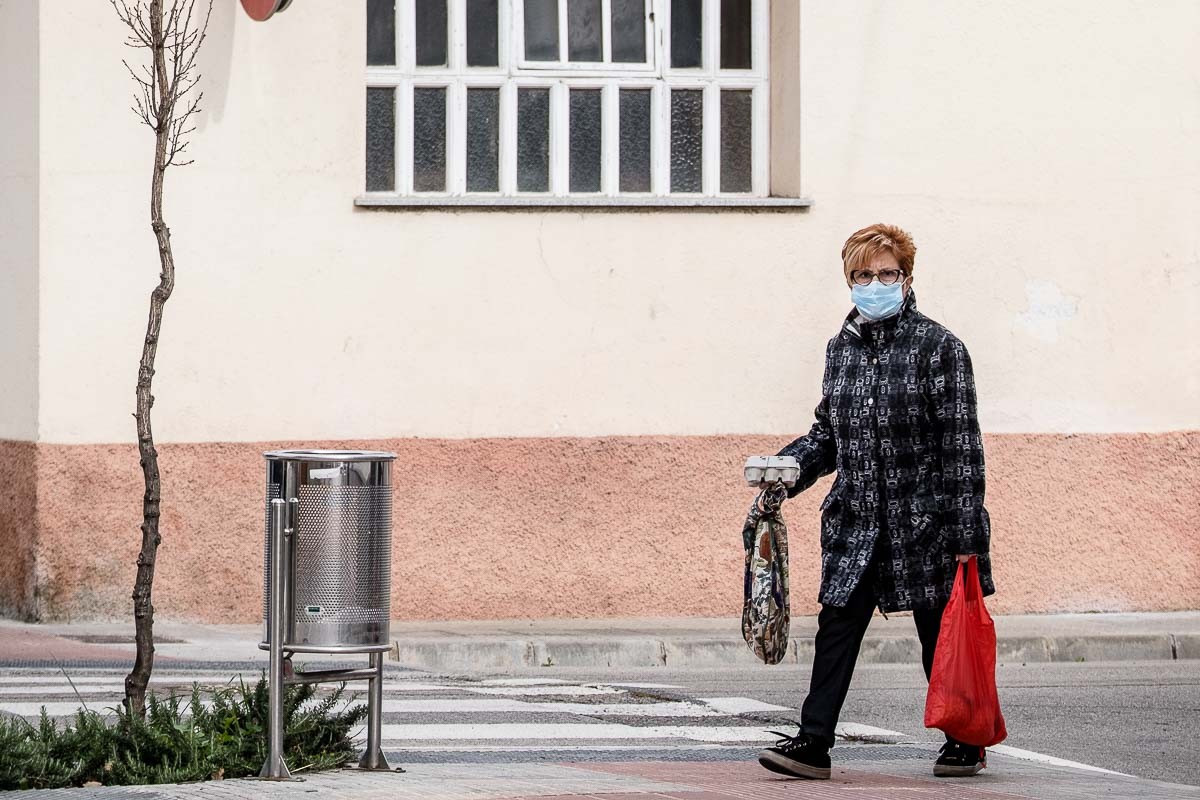 Una senyora protegida amb una mascareta torna de fer la compra - Adrià Costa