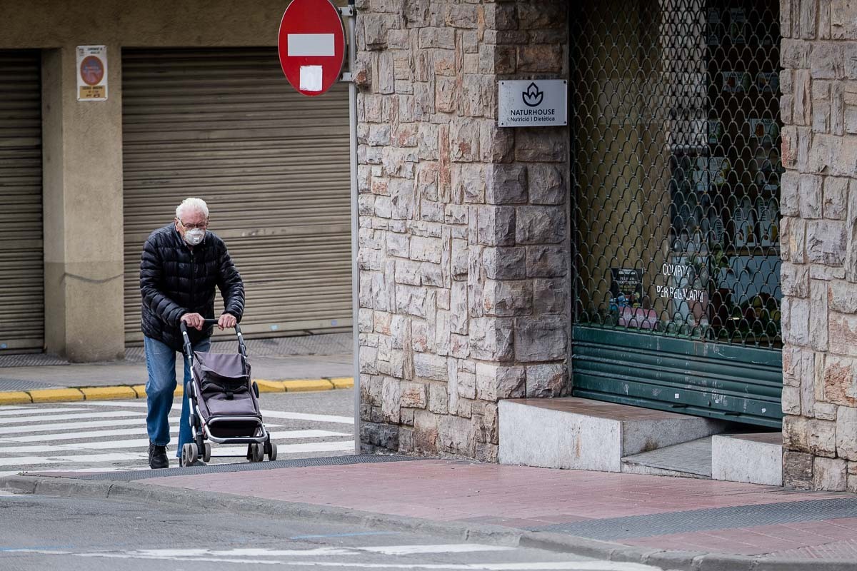Un home amb mascareta i carro de la compra, a Manlleu. - Adrià Costa
