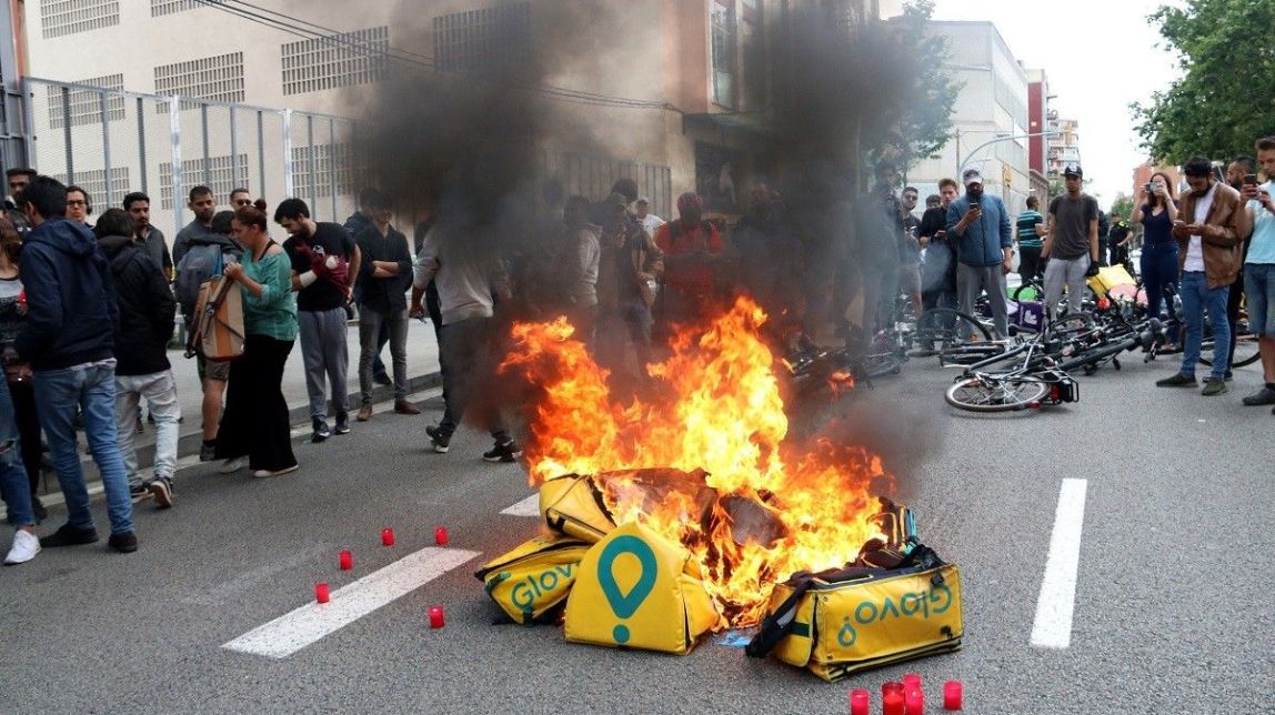 FOTOS I VÍDEOS Desenes de treballadors de Glovo es concentren davant la seu i cremen les seves motxilles