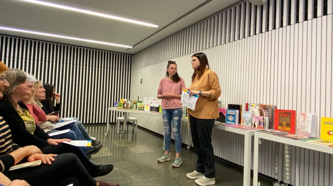 Foto de la mateixa activitat l’any passat (en aquest cas, apareixen la Violeta i Ester Barniol, directora de la biblioteca) i el cartell. - 