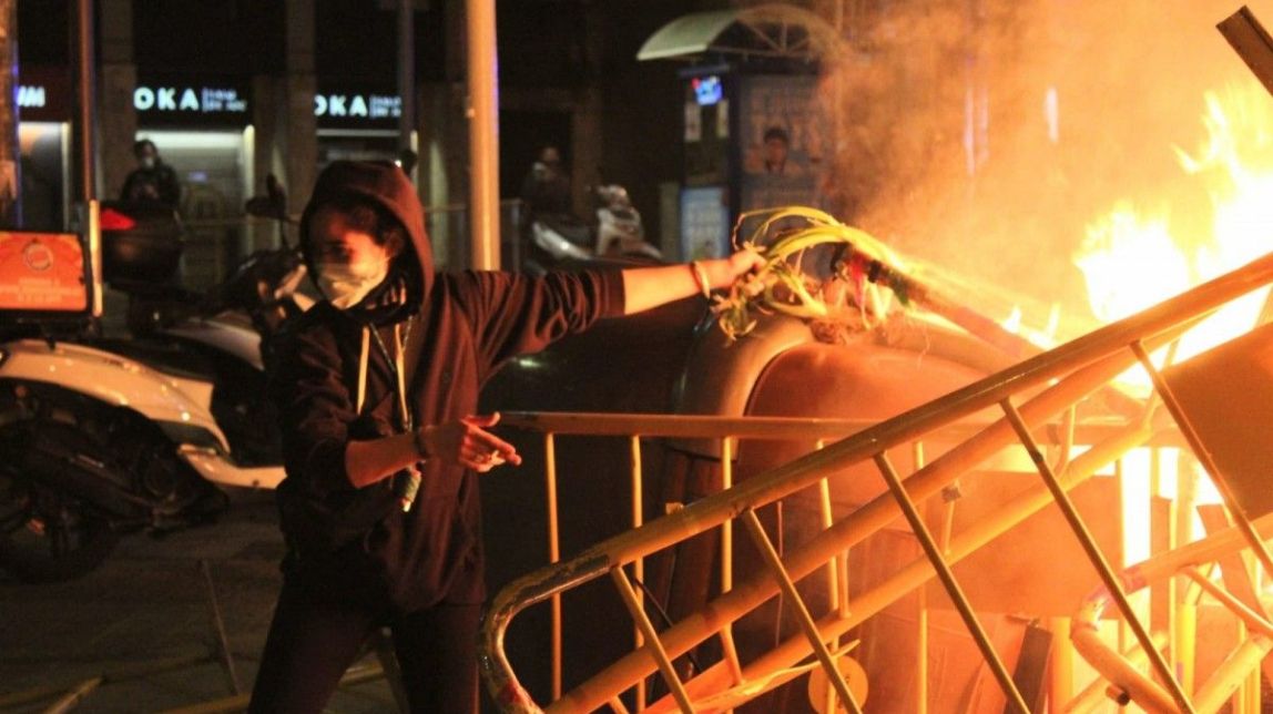 FOTO Una manifestant cou calçots amb el foc d'una barricada a Barcelona