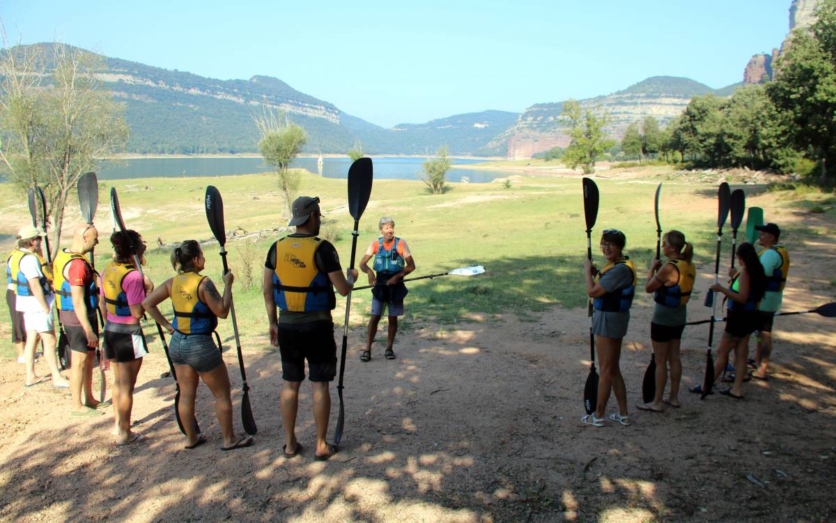 Un grup de persones rebent formació per fer una excursió amb caiac al pantà de Sau. - L.Casademont/ACN Un grup de persones rebent formació per fer una excursió amb caiac al pantà de Sau.