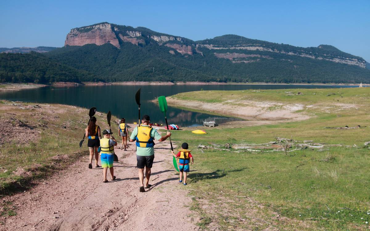 Un grup de persones rebent formació per fer una excursió amb caiac al pantà de Sau. - L.Casademont/ACN Un grup de persones rebent formació per fer una excursió amb caiac al pantà de Sau.