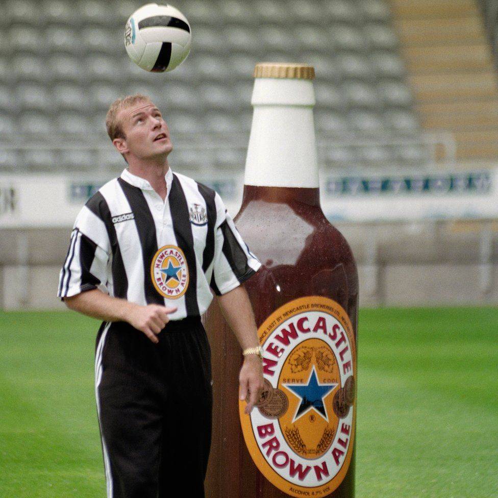 El davanter Alan Shearer amb una ampolla gegant de la cervesa Newcastle Brown Ale