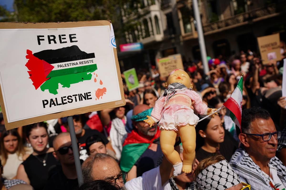 Una pancarta i un nino de plàstic amb el mocador palestí - Joan Mateu Parra / acn