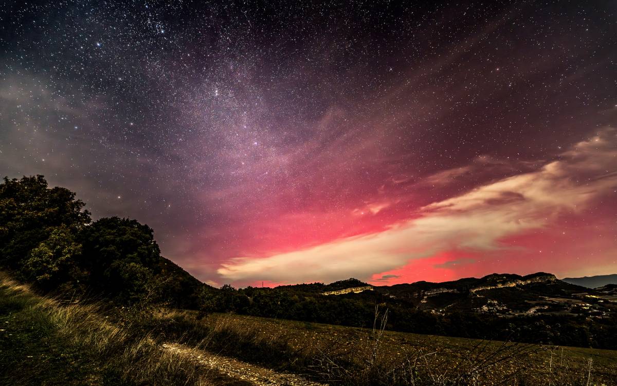 Una aurora boreal tenyeix de tons rosats el cel d'Osona