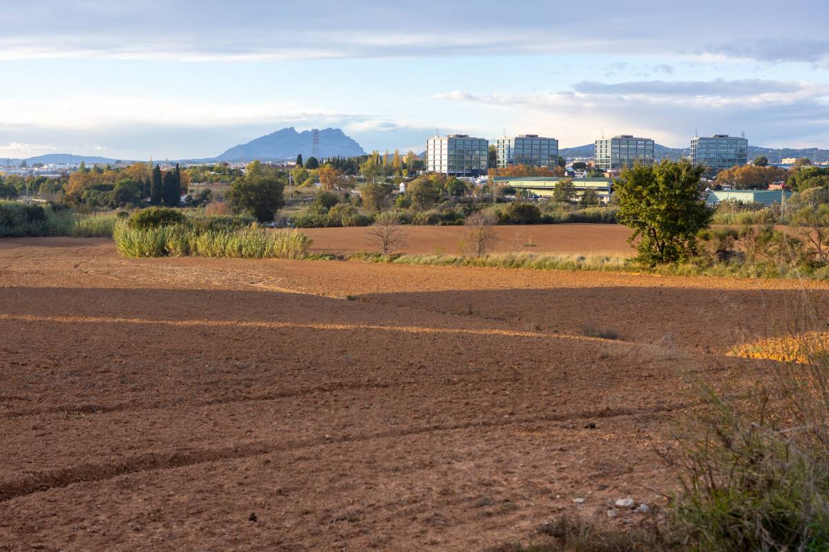 Al fons, una de les vies de Renfe, entre Sant Cugat i Rubí, on s`havia plantejat fer una estació d`AVE en el passat