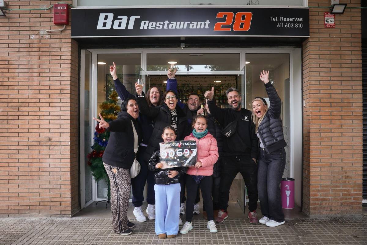Alguns dels clients i la propietària del bar que ha repartit el tercer premi de la Loteria de Nadal, a Sant Boi de Llobregat