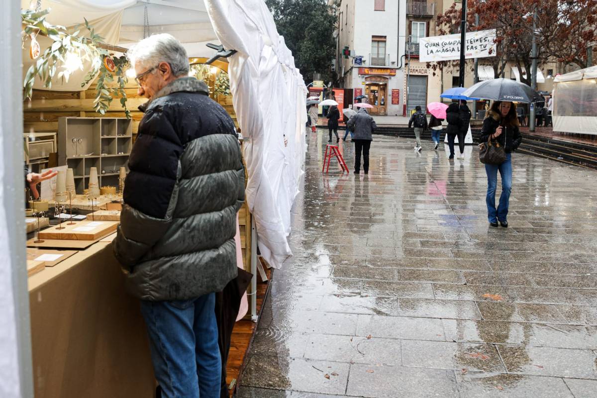 Tot i les dificultats amb la pluja, algun client s'acostava a les carpes obertes cercant algun producte - Lluís Clotet