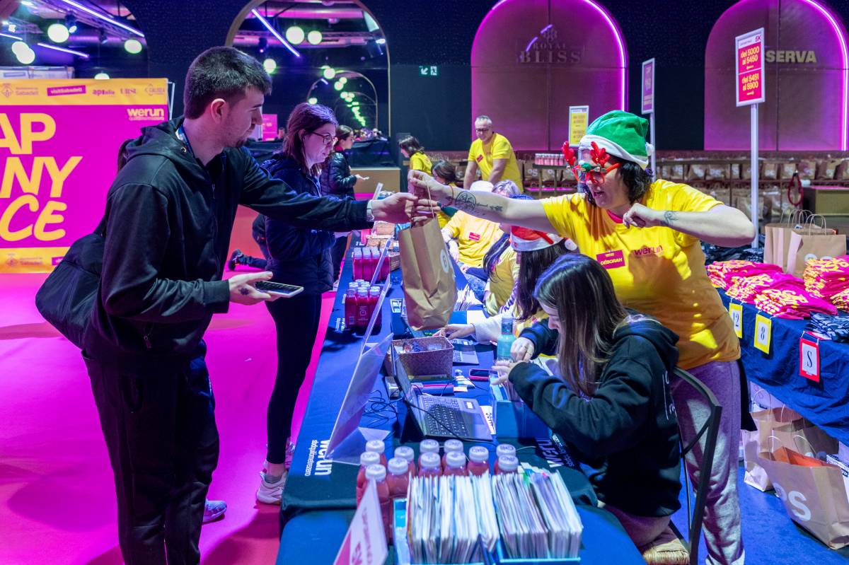 Els membres de l`organització, entregant la bossa del corredor a un dels inscrits