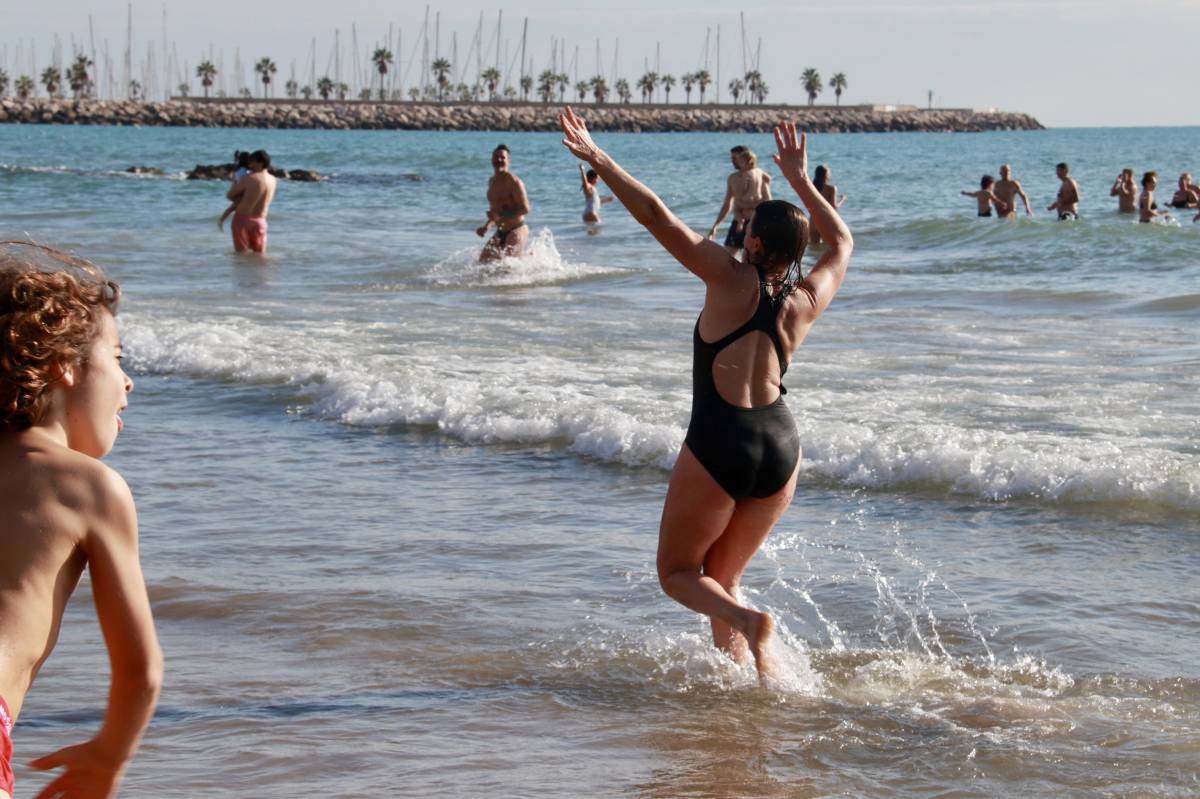 Una noia balla dins l'aigua a Sitges durant la Capbussada - ACN / Gemma Sánchez