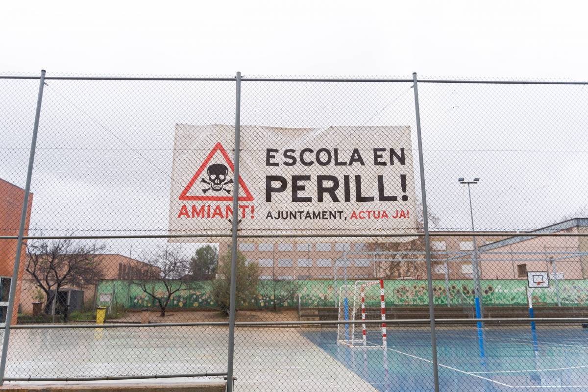 La pancarta reivindicativa que penja del pati de l`escola