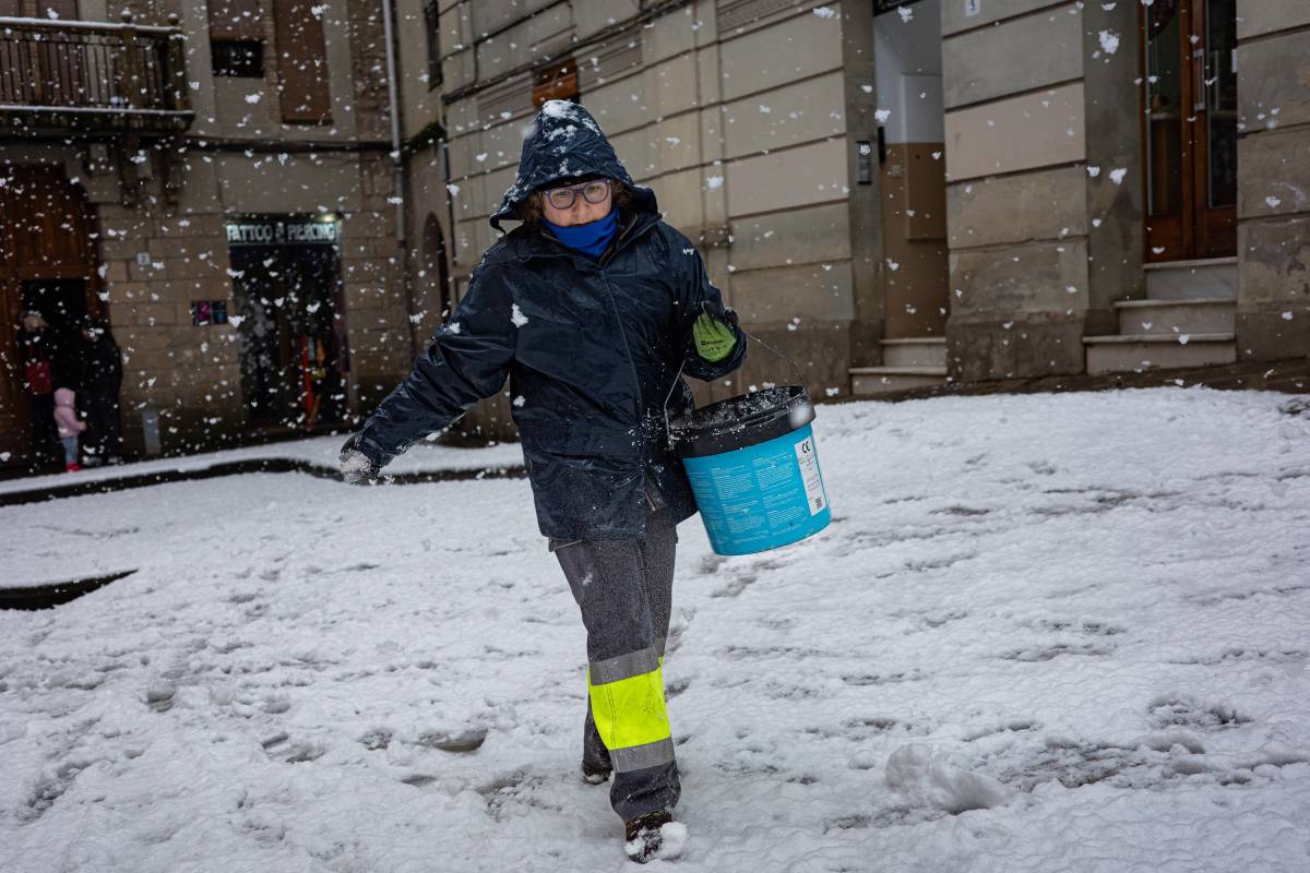Una operària de la brigada de l'Ajuntament escampa sal pels carrers del nucli antic de Solsona - Jordi Borràs 