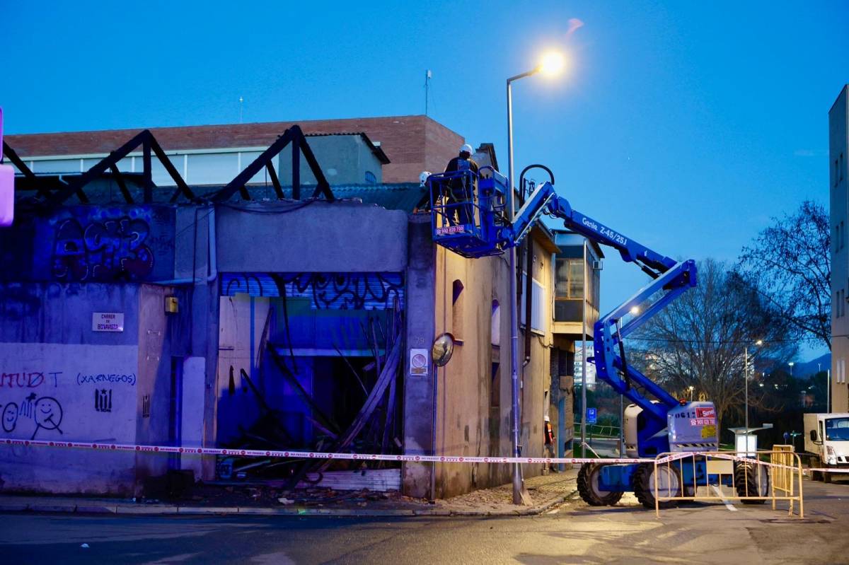 Operaris fent tasques de revisió de la façana de la nau industrial hores després del succés