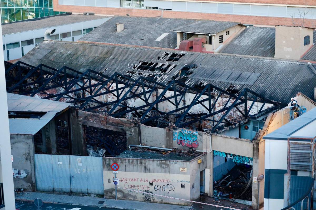 Operaris fent tasques de revisió de la façana de la nau industrial hores després del succés