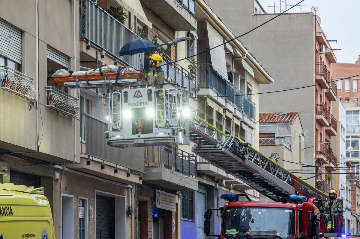 FOTOS | Evacuació sota la pluja d'un home de l'interior del seu domicili