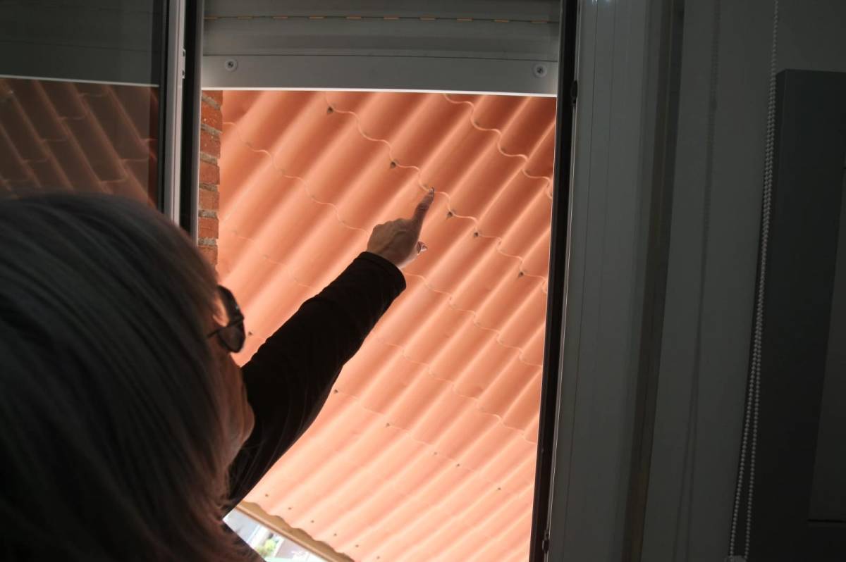 Una veïna mostrant la placa que s'ha arrencat de la coberta i ha quedat penjant de l'edifici - Nebridi Aróztegui