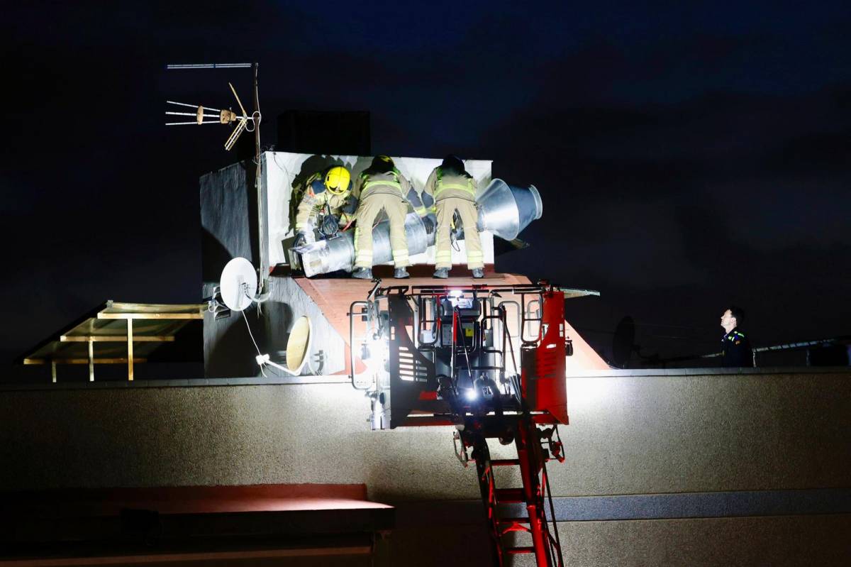 FOTOS | Retiren l'extractor de fums d'un edifici per risc de caiguda