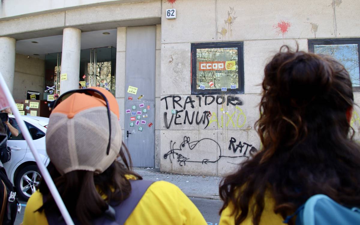 Manifestants cridant davant l`edifici de CCOO i UGT a Manresa, amb una rata pintada