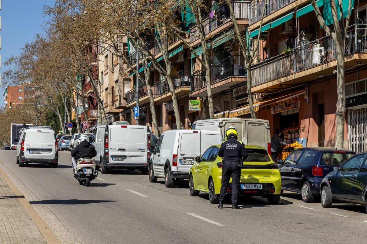 Policia Municipal multant vehicles estacionats en doble fila