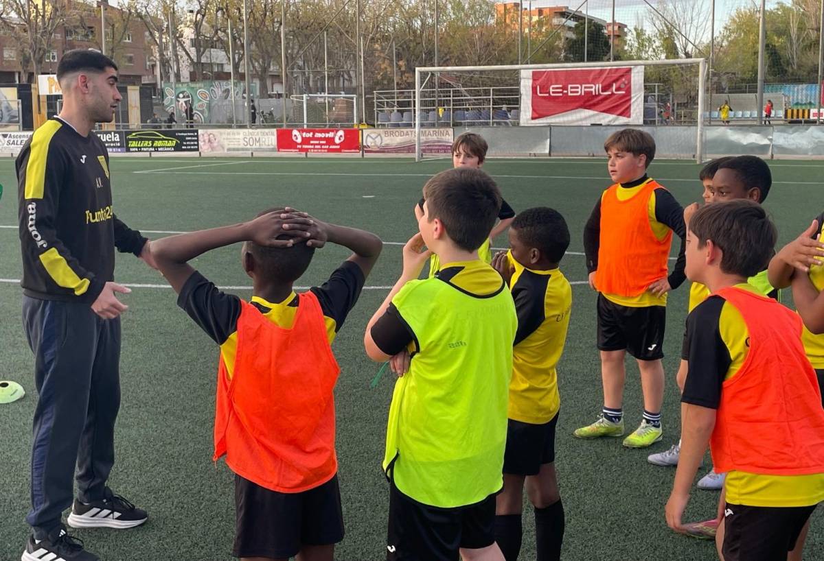 Joves futbolistes escoltant les indicacions de l’entrenador - C.F Pardinyes