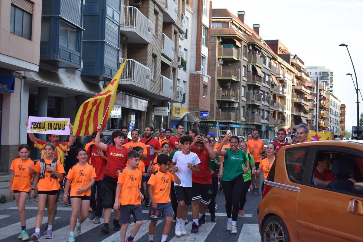 Corredors del Correllengua Agermanat arribant a la plaça del Carrilet de Tortosa amb la flama.